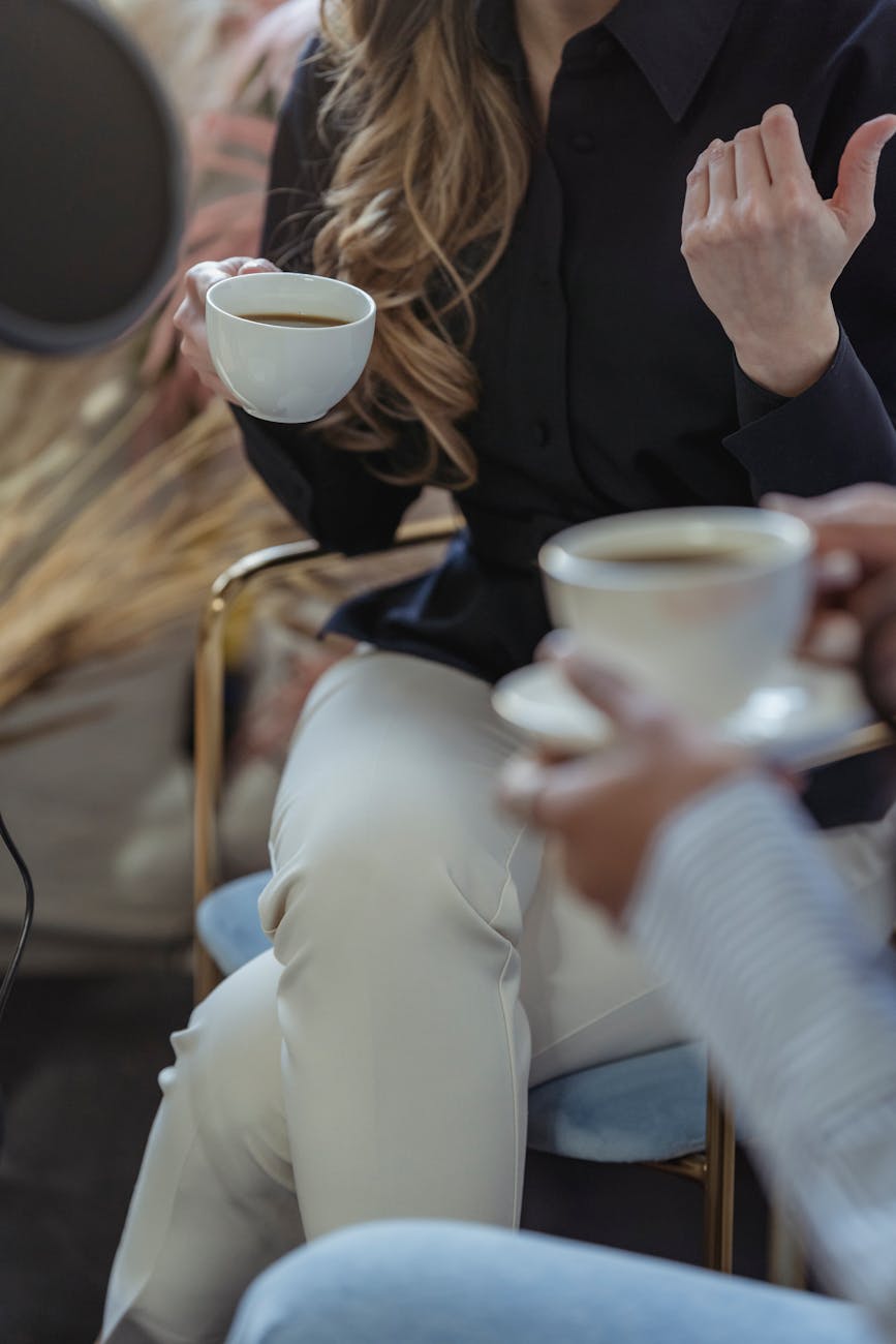 woman drinking coffee from ceramic cups during interview